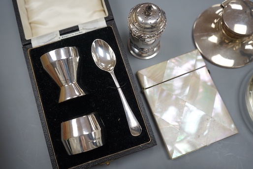 A 1930's cased silver christening trio, a silver mounted inkwell, a silver pepperette, a silver mounted glass match strike/ashtray and a mother of pearl card case.